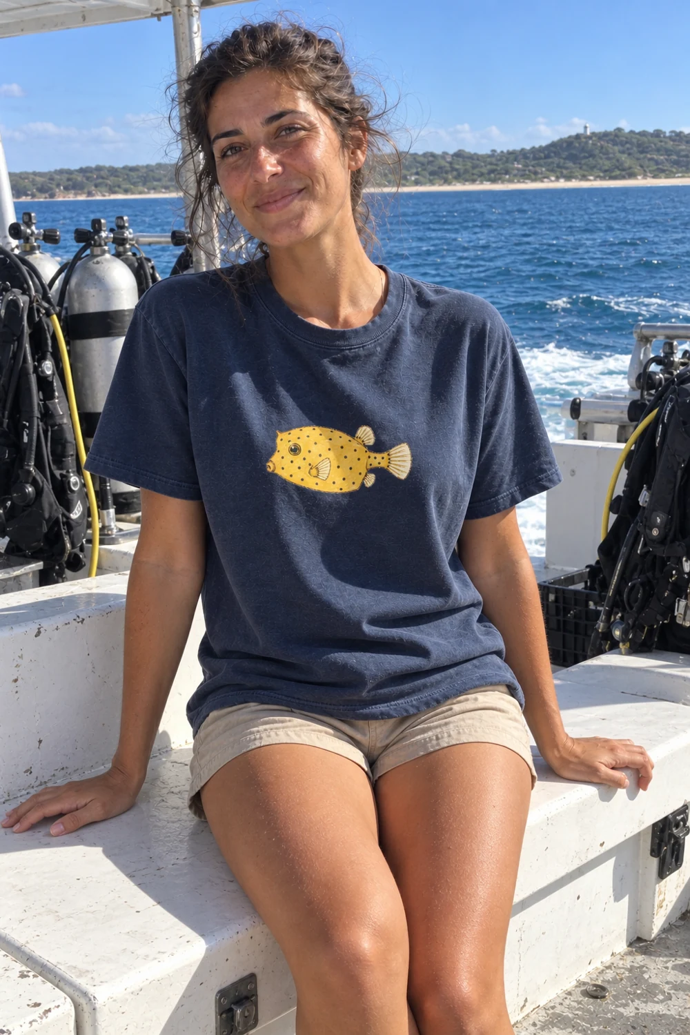 Woman wearing the navy Little Shoal yellow boxfish T-shirt on a dive boat