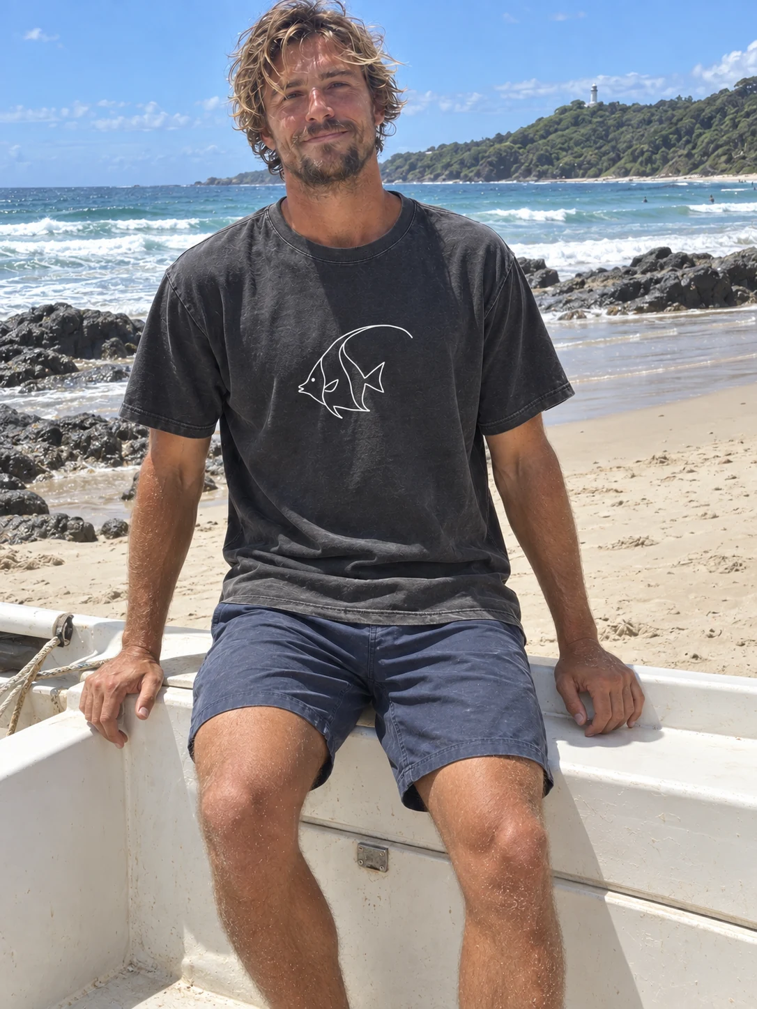 Man wearing the black Night Dive Moorish idol T-shirt by the sea